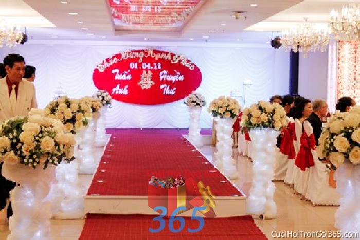 Cho thuê trang trí sân khấu tông màu trắng đỏ với voan và bảng tên trong nhà hàng tiệc cưới cho ngày đám cưới SKNH26 : Mẫu cưới hỏi trọn gói 365 của công ty dịch vụ trang trí nhà tiệc cưới hỏi đẹp rẻ uy tín ở tại quận Tân Phú Sài Gòn TPHCM Gò Vấp
